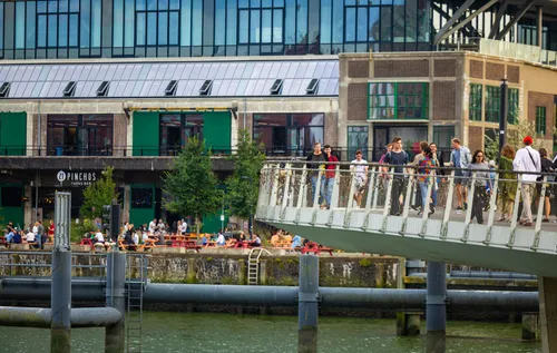 Een foto van mensen op de Rijnhavenbrug met op de achtergrond het terras van de Fenix Food Factory