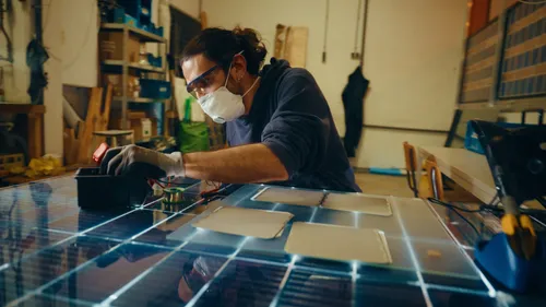 Photo of a young man working on Biosphere Solar's innovation at BlueCity.