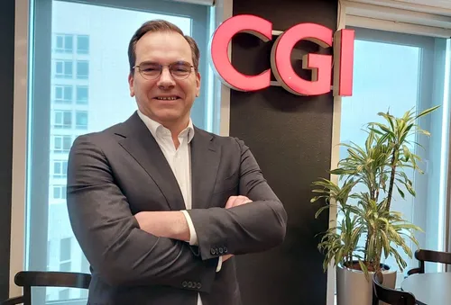 Photo of Joost van der Burgh, Senior Vice-President and BU Leader Central & South Netherlands. Joost poses in the CGI office. The CGI logo is visible.
