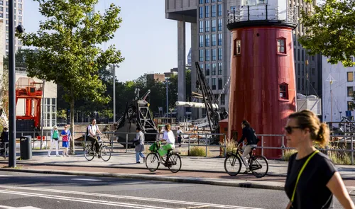 Een foto van fietsers en een wandelaar op de Schiedamsedijk in de zomer