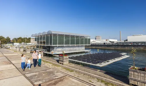Een foto van mensen en kinderen op de kade van de Floating Farm