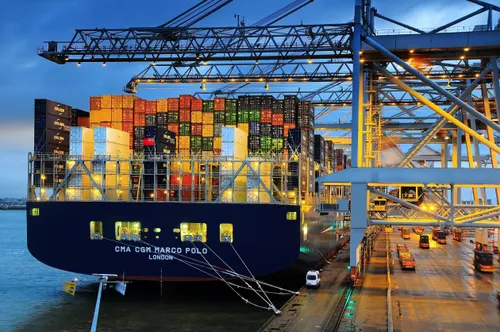 Phoeo: Ship moored at a quay in Rotterdam's port. Cranes and containers visible.