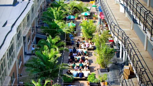 Photo: office workers enjoying a relaxed lunch in the sun at the outdoor terrace of co-working hub Het Industriegebouw