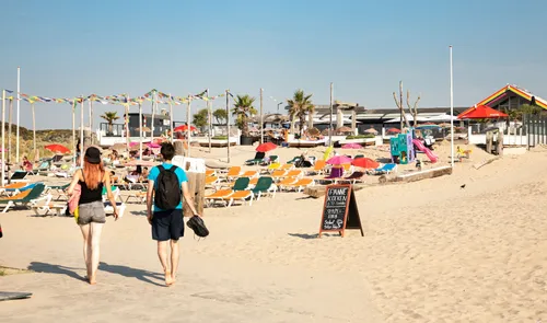 Een foto van wandelaars op het strand van Hoek van Holland in de zomer