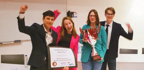 Photo of students posing with their trophy after winning the ILTS debating contest.