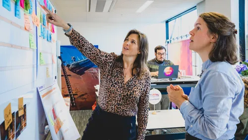 Photo: two people looking at a planning board at PortXL