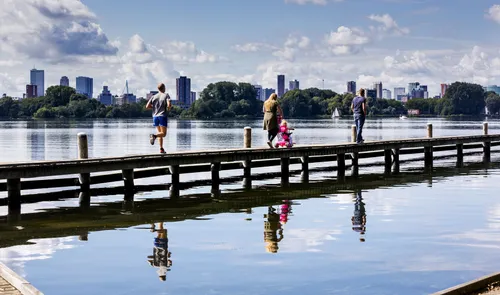Een foto van wandelaars en sporters op een steiger in de Kralingse Plas