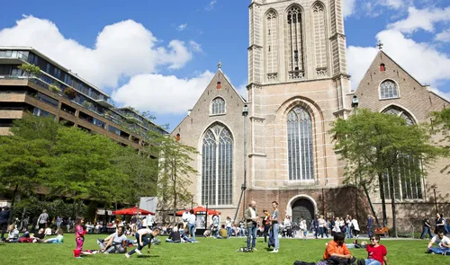 Een foto van bezoekers in het Stadspark Groterkerkplein voor de Laurenskerk