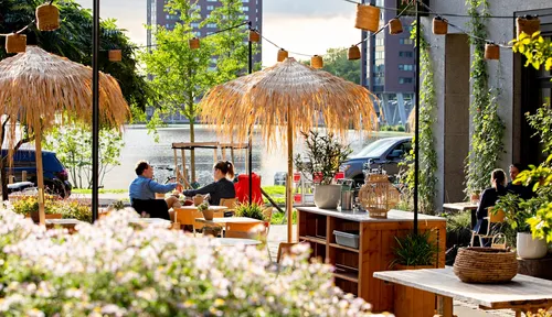 Photo: people enjoying a sunny day at a terrace near the LittleC housing complex.