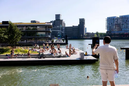 Man taking a picture of people enjoying a swim from the floating pontoon at Rijnhaven, Rotterdam