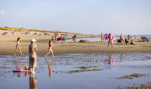 Een foto van recreanten op het strand bij de Maasvlakte