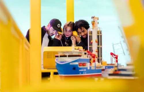 Bezoekers bekijken een scheepsmodel in een interactieve tentoonstelling van het Maritiem Museum Rotterdam.