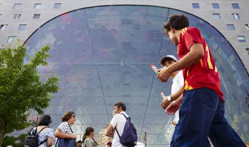 Een foto van mensen voor de Markthal in de zomer