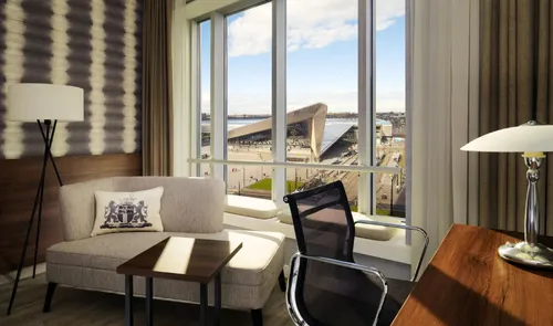 Een foto van een kamer met een bank in het Marriott Hotel met uitzicht op het Rotterdam Centraal Station