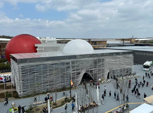 Photo of the Dutch pavillion at the World Expo in Osaka. We seen people walking the square in front of the pavillion.,