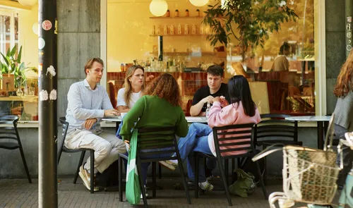 Een foto van mensen op het terras van Wolly aan de Waterkant bij het Noordplein