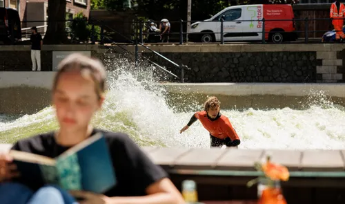 Een surfer bij RiF010 met op de voorgrond een vrouw die aan het lezen is