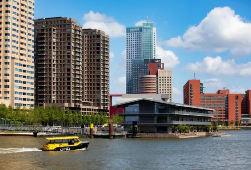 Floating office on the Rijnhaven in Rotterdam, with a water taxi speeding past.