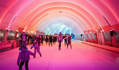 Een foto van kinderen en volwassenen aan het schaatsen op Schaatsbaan Rotterdam in de winter