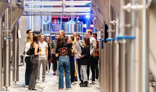 Een foto van mensen die de Stadshaven Brouwerij bezoeken en een rondleiding krijgen door de brouwerij