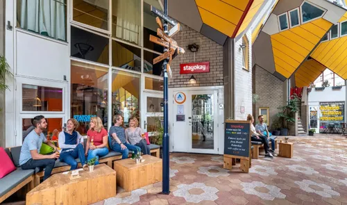 Mensen bij de entree van Stayokay Hostel bij de Kubuswoningen