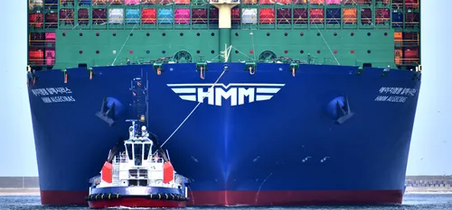 Photo: tugboat with a large container ship at the Port of Rotterdam