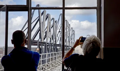 Een foto van bezoekers aan de Van Nellefabriek met zicht op de letters bovenop het dak