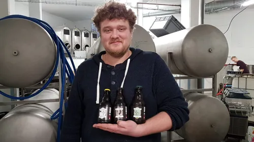Photo of Ruben Krommenhoek of circular brewery Vet & Lazy proudly showing some of his beers. Vet & Lazy is located at BlueCity.