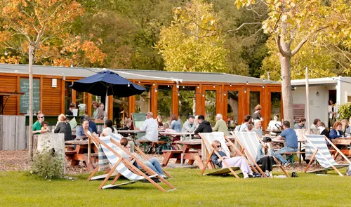 Een foto van mensen op het terras van het Vroesenpaviljoen in het Vroesenpark