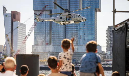 Een foto van kinderen die kijken naar een helikopter boven de Nieuwe Maas tijdens de Wereldhavendagen