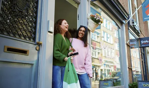 Twee dames die aan het winkelen zijn op het Zwaanhaals door Willem de Kam
