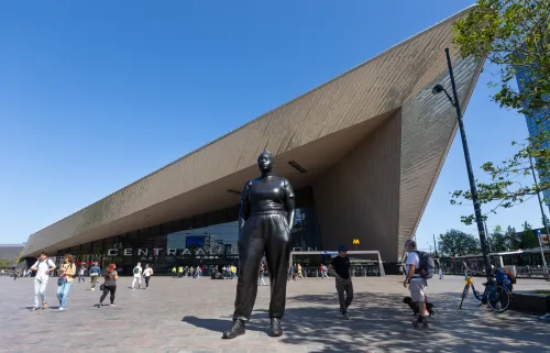 Moments Contained statue of a woman in front of Rotterdam Central Station.