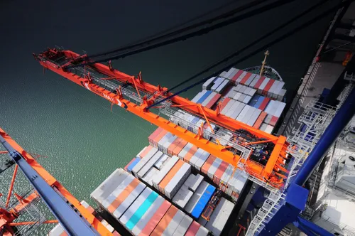 Photo: cranes over a container ship in the Port of Rotterdam