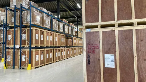 Warehouse interior with stacked wooden crates labeled Intellian on industrial shelving in the Netherlands