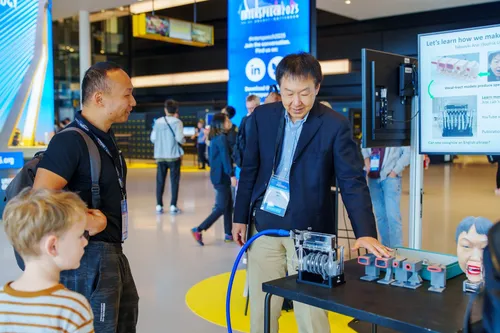 Photo of a man demonstrating a technological innovation at Interspeech 2025 in Rotterdam