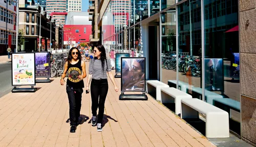 Photo of two young women walking down the Otto Reuchlinweg, Wilhelminakade (Rotterdam).