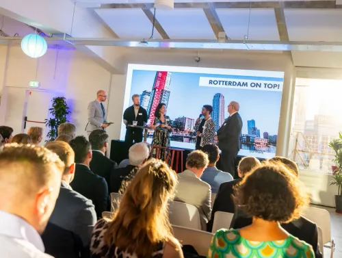 Photo of people on stage at Red Carpet Dinner 2023, with a captivated audience listening.