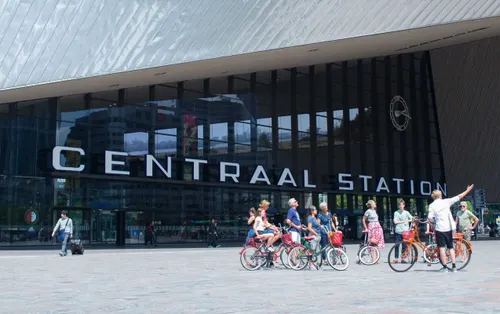 Photo of a group of people gathering at the square in front of Rotterdam Centraal Station with their bikes