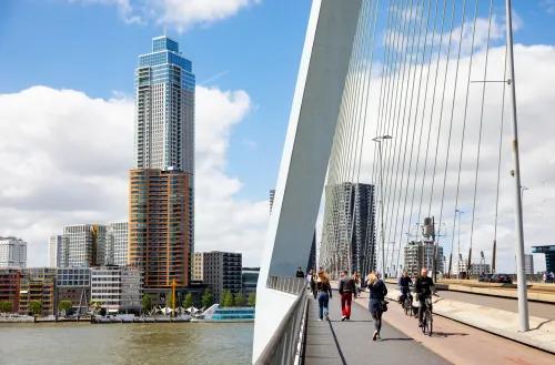 People walking on the erasmus bridge across the Maas.