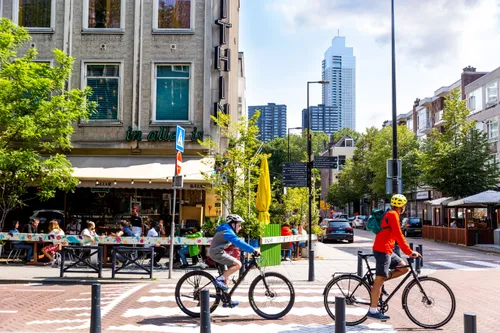 Biking through Rotterdam city like a local, cycling past cafes and boutiques.